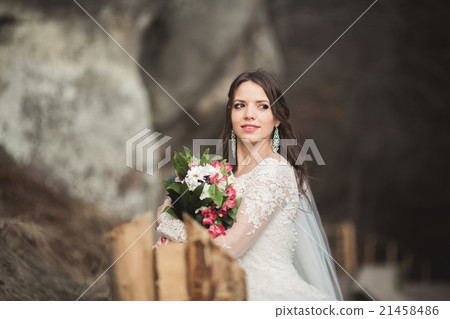 Beautiful bride posing near rocks with beautiful 21458486