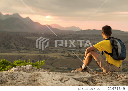 Hiker with backpack sitting on a rock 21471849
