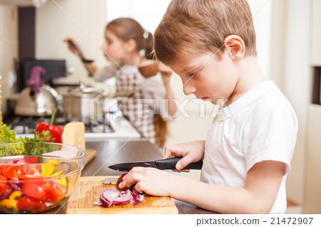 Small boy and his sister cooking in the kitchen Small boy and his sister cooking in the kitchen 21472907
