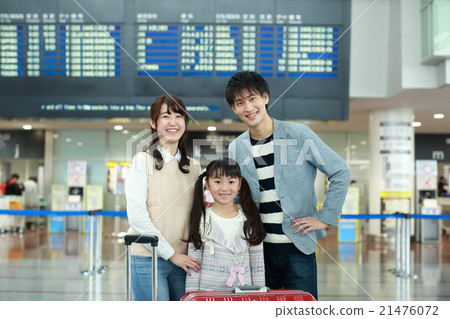 A family waiting for departure in front of the departure and arrival guide board 21476072