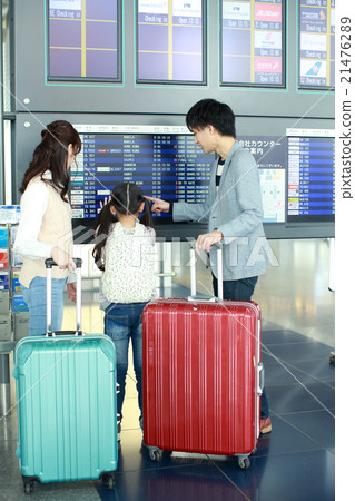 Family to see departure time in front of departure and arrival guide board 21476289