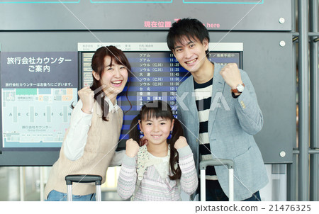 A family standing in front of the departure and arrival guide board 21476325