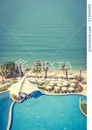 Umbrella and chair around swimming pool 21484409