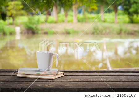 Coffee cup with notebook on rustic wood table Coffee cup with notebook on rustic wood table 21505168