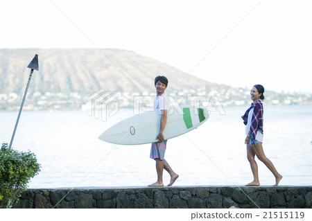 A couple walking along the beach A couple walking along the beach 21515119
