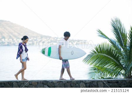 A couple walking along the beach 21515124