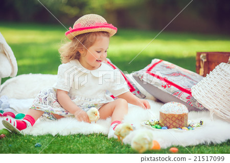 Happy child sits on a meadow around easter Happy child sits on a meadow around easter 21517099