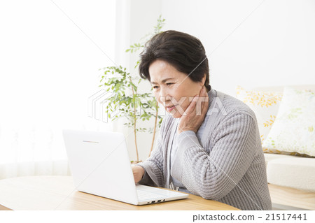 A senior woman operating a computer 21517441