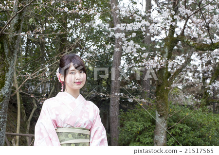 有一張微笑的面孔的一個少婦在走在Maruyama公園,Higashiyama病區,京都市的和服附近 有一張微笑的面孔的一個少婦在走在Maruyama公園,Higashiyama病區,京都市的和服附近 21517565