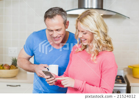 Cute couple looking at smartphone Cute couple looking at smartphone 21524012