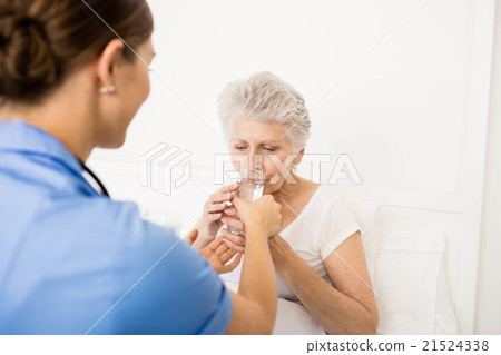 Nurse taking care of suffering senior patient Nurse taking care of suffering senior patient 21524338