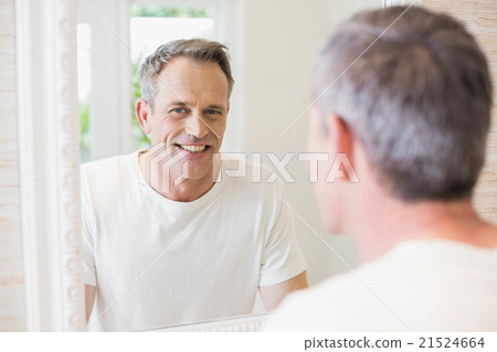 Handsome man looking at himself in the mirror Handsome man looking at himself in the mirror 21524664