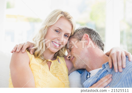Happy couple hugging on the couch Happy couple hugging on the couch 21525511