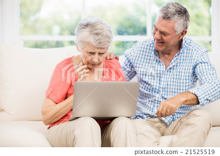 Smiling senior couple using laptop 21525519