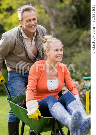 Husband pushing wife in a wheelbarrow Husband pushing wife in a wheelbarrow 21525633