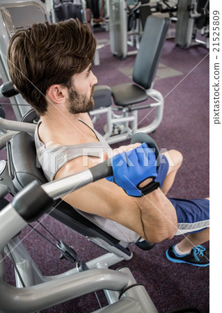 Focused man using weights machine for arms Focused man using weights machine for arms 21525809