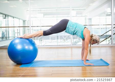 Fit blonde planking on mat with exercise ball 21525987