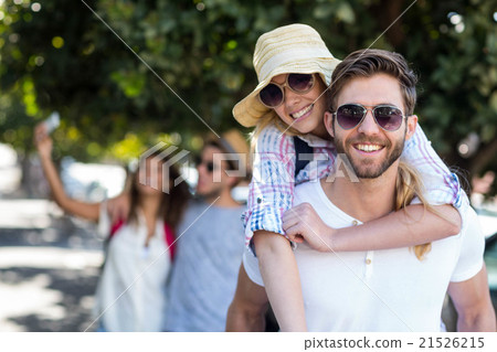 Hip man giving piggy back to his girlfriend Hip man giving piggy back to his girlfriend 21526215