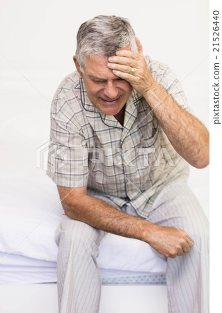 Suffering senior man touching his forehead Suffering senior man touching his forehead 21526440
