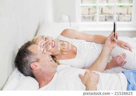 Cute couple using smartphone Cute couple using smartphone 21526625