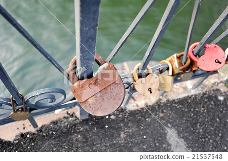 The couple hung a lock on the bridge railing The couple hung a lock on the bridge railing 21537548