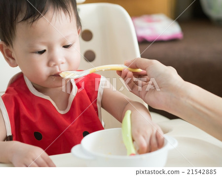 Asian toddler eat meal herself. Asian toddler eat meal herself. 21542885