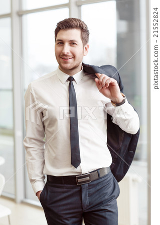 Positive business man holding jacket on the 21552824