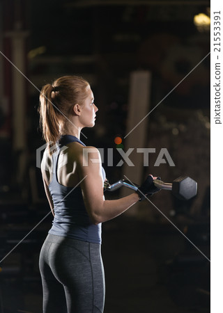 Young woman lifting the dumbbells 21553391