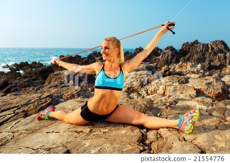 Athlete woman doing sport exercising with the rope on the rocks 21554776