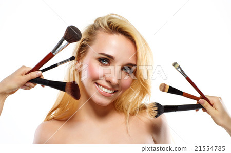 Smiling young woman with makeup brushes near her face 21554785