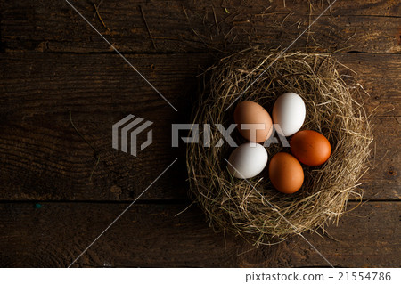Chicken eggs in a nest on a wooden rustic background 21554786