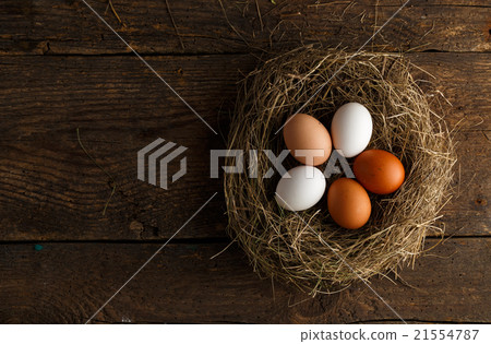 Fresh chicken eggs in a nest on a wooden background 21554787