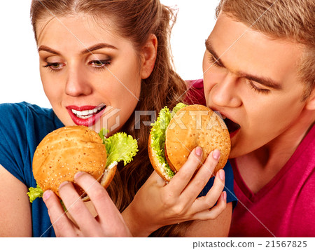 Woman feeds man fast food together. 21567825