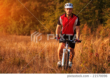 Man is riding a mountain bike in the field Man is riding a mountain bike in the field 21570096