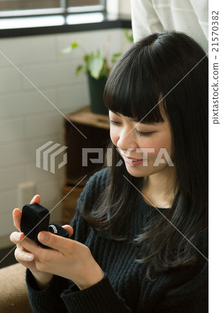 A woman who receives a present and smiles 21570382