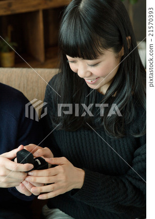 A woman who receives a present and smiles 21570393