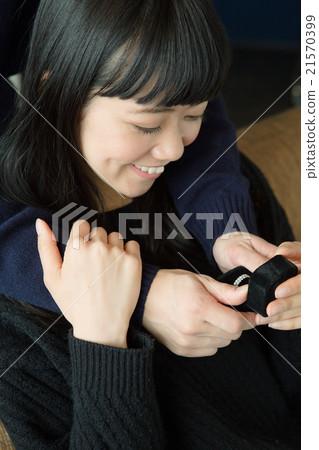 A woman who receives a present and smiles 21570399