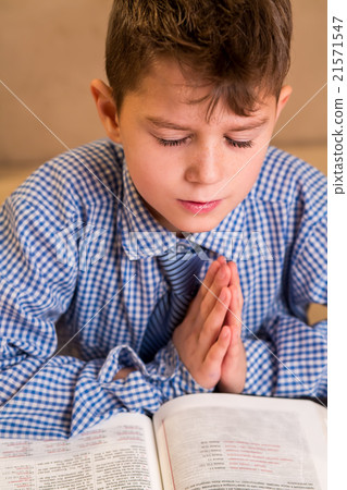 Boy praying with eyes closed. Boy praying with eyes closed. 21571547