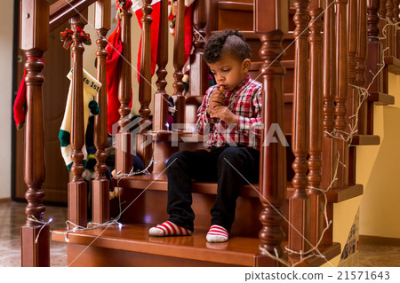 Mulatto child plays wind instrument.  21571643