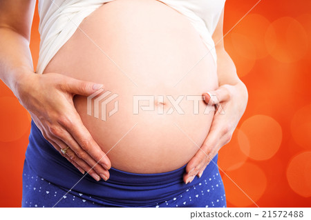 Composite image of pregnant woman holding her bump 21572488
