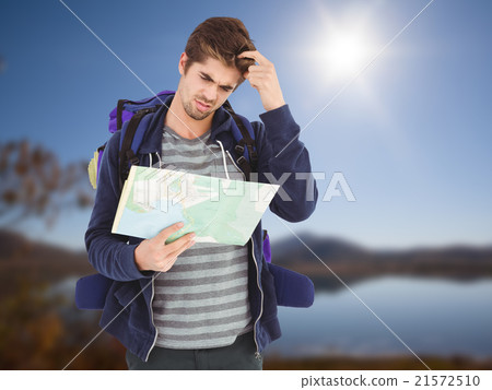 Composite image of man scratching head while looking in map Composite image of man scratching head while looking in map 21572510
