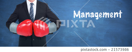 Composite image of businessman with boxing gloves 21573986