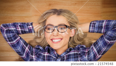 Composite image of a blonde hipster lying on the floor 21574548