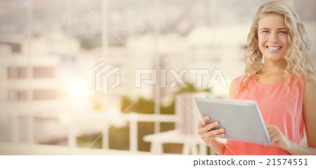 Composite image of portrait of smiling woman using digital table 21574551
