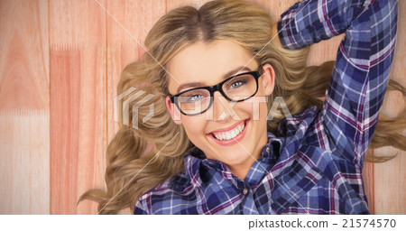 Composite image of portrait of a blonde hipster lying on the flo Composite image of portrait of a blonde hipster lying on the flo 21574570