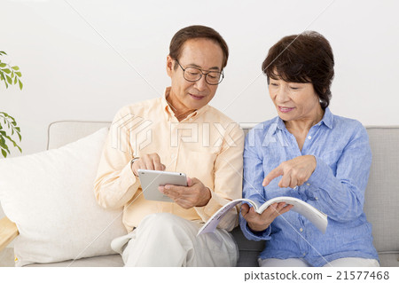Senior couple looking at mail-order catalog together 21577468