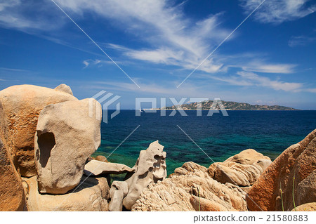 Boat with blurred paraglide behind the rocks 21580883