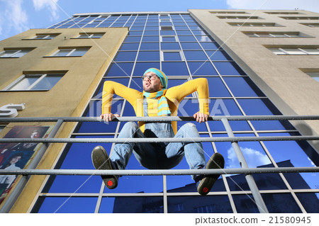 .a young man in overalls on background glassed building .a young man in overalls on background glassed building 21580945