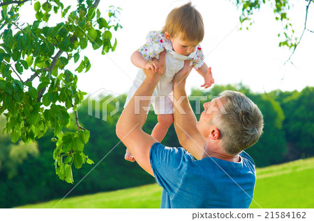 Dad with a baby outdoors.  21584162