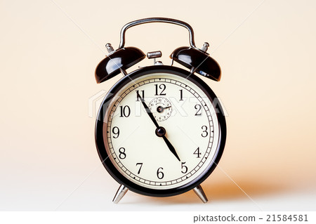 Black old fashioned alarm clock, beige background 21584581